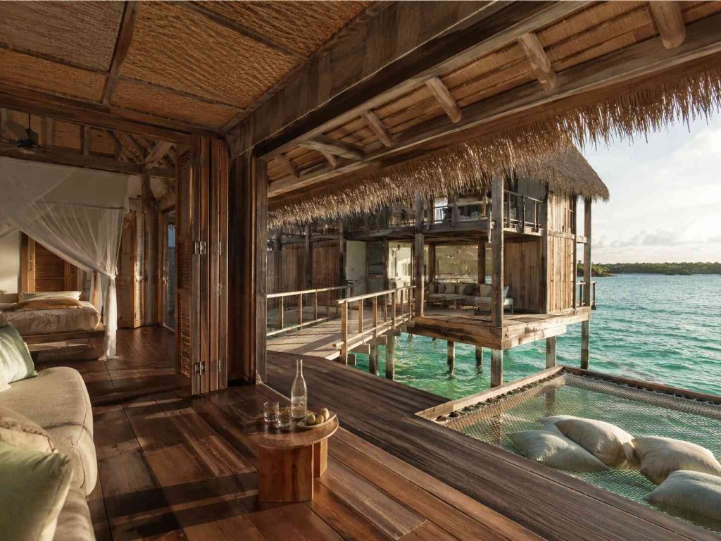 Multi-level Crusoe Residence interior at Gili Lankanfushi with timber pavilions connected by walkway above turquoise Maldives lagoon
