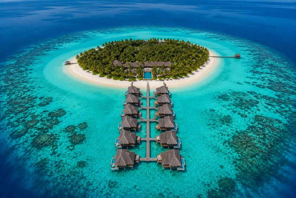 Aerial view of a private island overwater villa resort in the Maldives Indian Ocean
