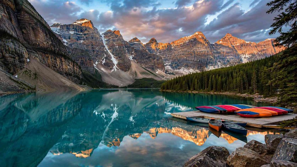 Moraine Lake turquoise water reflecting Rocky Mountains at sunrise in Banff National Park Canada