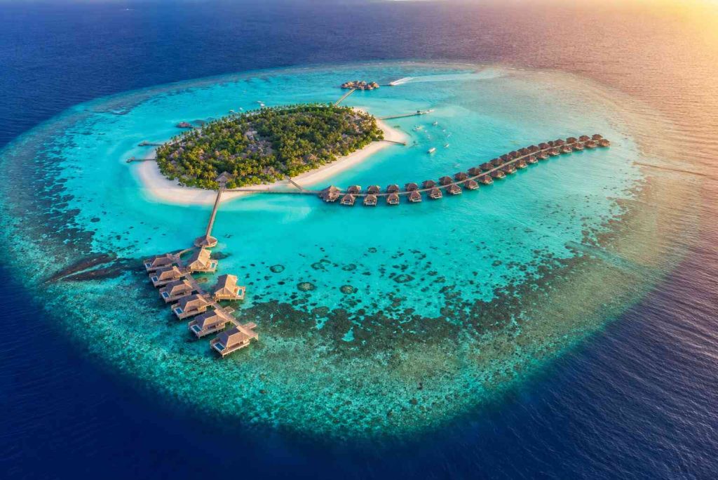 Aerial view of private island resort in Maldives surrounded by turquoise Indian Ocean
